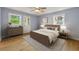 Cozy bedroom with light blue walls, two windows, and light wood colored floors at 1773 Kimberly Sw Dr, Marietta, GA 30008