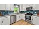 Modern kitchen featuring stainless steel appliances, granite counters, and blue subway tile at 1773 Kimberly Sw Dr, Marietta, GA 30008