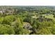 Aerial shot showcasing a home nestled amidst lush greenery and mature trees, with nearby neighborhood and open land at 922 Florence Rd, Douglasville, GA 30134