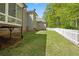 Backyard view with a white picket fence, mature trees, and lush green lawn at 922 Florence Rd, Douglasville, GA 30134