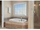 Bathroom featuring a soaking tub with tile surround and a glass-enclosed shower at 922 Florence Rd, Douglasville, GA 30134