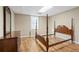 A bedroom space featuring hardwood floors, light-colored walls, and an unfinished wooden four-poster bed frame at 922 Florence Rd, Douglasville, GA 30134