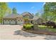 Stately brick and stone home with a three-car garage, manicured lawn, and mature landscaping at 922 Florence Rd, Douglasville, GA 30134