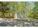 Two-car detached garage with concrete driveway and surrounded by mature trees and greenery at 922 Florence Rd, Douglasville, GA 30134