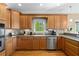 Well-lit kitchen with wood cabinets, stone backsplash, and stainless steel appliances at 922 Florence Rd, Douglasville, GA 30134