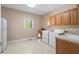 Bright laundry room equipped with white appliances, cabinetry, and tile flooring at 922 Florence Rd, Douglasville, GA 30134