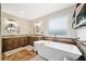 This bathroom features a standalone tub, wooden cabinets, granite countertops, and a neutral color palette at 1039 Avery Creek Dr, Woodstock, GA 30188