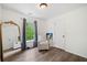 A light-filled bedroom with wood floors, a window, and a full-length mirror at 1039 Avery Creek Dr, Woodstock, GA 30188