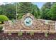 The entrance to Bradshaw Farm featuring stone accents, manicured landscaping, and a welcoming sign at 1039 Avery Creek Dr, Woodstock, GA 30188