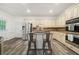 Bright kitchen featuring stainless steel appliances, a center island with seating, and stylish wood-look flooring at 1039 Avery Creek Dr, Woodstock, GA 30188