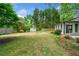 Expansive backyard features a lush lawn, mature trees, a storage shed, and a stone patio for outdoor enjoyment at 1492 Frazier Rd, Decatur, GA 30033