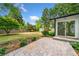Enjoy the beautiful backyard with a stone patio, green grass, mature trees, and a storage shed for outdoor equipment at 1492 Frazier Rd, Decatur, GA 30033