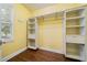 Spacious walk-in closet features custom shelving, drawers, and a hanging rod for optimal organization in a sunny yellow room at 1492 Frazier Rd, Decatur, GA 30033