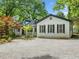 Inviting home exterior with mature trees, gravel driveway, and well-maintained landscaping creates a welcoming ambiance at 1492 Frazier Rd, Decatur, GA 30033