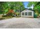 Charming home with a gravel driveway, manicured lawn, and lush landscaping offers great curb appeal at 1492 Frazier Rd, Decatur, GA 30033