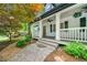 Inviting front porch with white columns and a stone walkway, framed by lush landscaping at 1492 Frazier Rd, Decatur, GA 30033