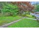 The serene backyard offers a lush lawn, mature trees, and a charming view of the property's exterior at 2685 Harrington Dr, Decatur, GA 30033