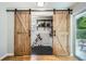 Modern laundry room features stylish barn doors, white subway tile, floating shelves, and black hexagon tile flooring at 2685 Harrington Dr, Decatur, GA 30033
