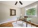 Bright home office with a modern glass desk, hardwood floors, ceiling fan, and a large window with a green view at 2685 Harrington Dr, Decatur, GA 30033
