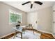 Inviting home office with modern desk, hardwood floors, ceiling fan, and natural light from the large window at 2685 Harrington Dr, Decatur, GA 30033