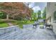 A stone patio features outdoor seating and a view of the landscaped backyard and mature trees at 2685 Harrington Dr, Decatur, GA 30033