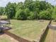Large, grassy backyard featuring a privacy fence, patio area, and mature trees at 432 Creekside Park, Covington, GA 30014