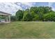 Large grassy backyard with mature trees and covered patio at 432 Creekside Park, Covington, GA 30014