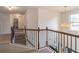 Upstairs hallway featuring iron and wood railings, leading to a room full of natural light at 432 Creekside Park, Covington, GA 30014
