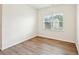 This room features wood-look flooring, neutral paint, and a window with natural light at 4615 Elmwood Trl, Cumming, GA 30028