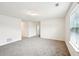 A well-lit room with soft carpet, a window, and easy access to other rooms in the home at 4615 Elmwood Trl, Cumming, GA 30028