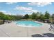 Outdoor community pool with lounge chairs and tables surrounded by a black metal fence at 4615 Elmwood Trl, Cumming, GA 30028
