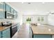 A well lit kitchen features an island, stainless steel appliances, granite countertops and beautiful blue cabinetry at 4615 Elmwood Trl, Cumming, GA 30028