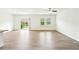 Sunlit living room with wood floors and sliding door to backyard at 4615 Elmwood Trl, Cumming, GA 30028