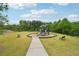 Community playground with a playset, two benches, and a sidewalk surrounded by green grass and trees at 4615 Elmwood Trl, Cumming, GA 30028