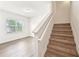 Bright entryway featuring wood-look flooring and a carpeted staircase with white banister at 4615 Elmwood Trl, Cumming, GA 30028