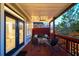 Cozy covered porch with dark wood floors, ceiling fan, seating, and soft outdoor lighting at 94 Hogue Ne St, Atlanta, GA 30312