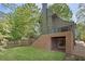 A lush backyard with a covered brick patio, an adjacent lawn, and a staircase to the main level at 1026 Reeder Cir, Atlanta, GA 30306
