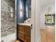 Stylish bathroom with marble walk-in shower, custom vanity, gold fixtures, and unique accent wall at 1026 Reeder Cir, Atlanta, GA 30306
