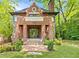 Beautiful brick home featuring a manicured front lawn, front porch, and lush surrounding trees at 1026 Reeder Cir, Atlanta, GA 30306