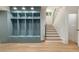A stylish mudroom features built-in blue storage lockers with drawers and hooks alongside wooden stairs at 1026 Reeder Cir, Atlanta, GA 30306