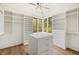 Spacious walk-in closet with custom shelves, drawers, island with drawers, and a large window view at 1026 Reeder Cir, Atlanta, GA 30306
