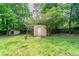 Backyard showing grass, trees, and storage sheds at 1615 Enchanted Forest Dr, Conley, GA 30288