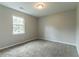Bright bedroom showcasing neutral walls, carpet, and a window inviting natural light and comfort at 1615 Enchanted Forest Dr, Conley, GA 30288