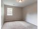 An empty bedroom boasts neutral paint, carpet and a window, ready for personalization and comfort at 1615 Enchanted Forest Dr, Conley, GA 30288