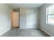 The bedroom boasts plush carpeting and a window for great natural light, complete with closet and doorway at 1615 Enchanted Forest Dr, Conley, GA 30288