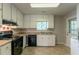Functional kitchen with white cabinets, black appliances and window above the sink at 1615 Enchanted Forest Dr, Conley, GA 30288