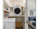 Compact laundry area with stacked washer and dryer, and open shelving for efficient storage solutions at 215 Piedmont Ne Ave # 2210, Atlanta, GA 30308