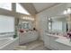 Bright bathroom featuring dual sinks, a tub, and a door leading to another room at 4290 Grand Teton Pkwy, Suwanee, GA 30024