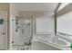 Bright bathroom featuring a shower, tub, and natural lighting from a window at 4290 Grand Teton Pkwy, Suwanee, GA 30024