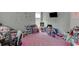 Bright bedroom with pink carpet, decorated walls, toys, and large window allowing ample natural light at 4290 Grand Teton Pkwy, Suwanee, GA 30024